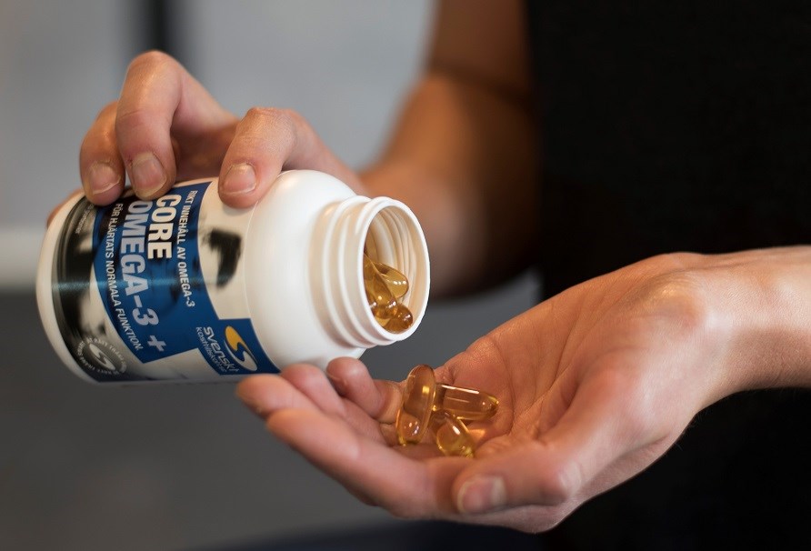 Omega-3 kapsler hldes op i en hnd.